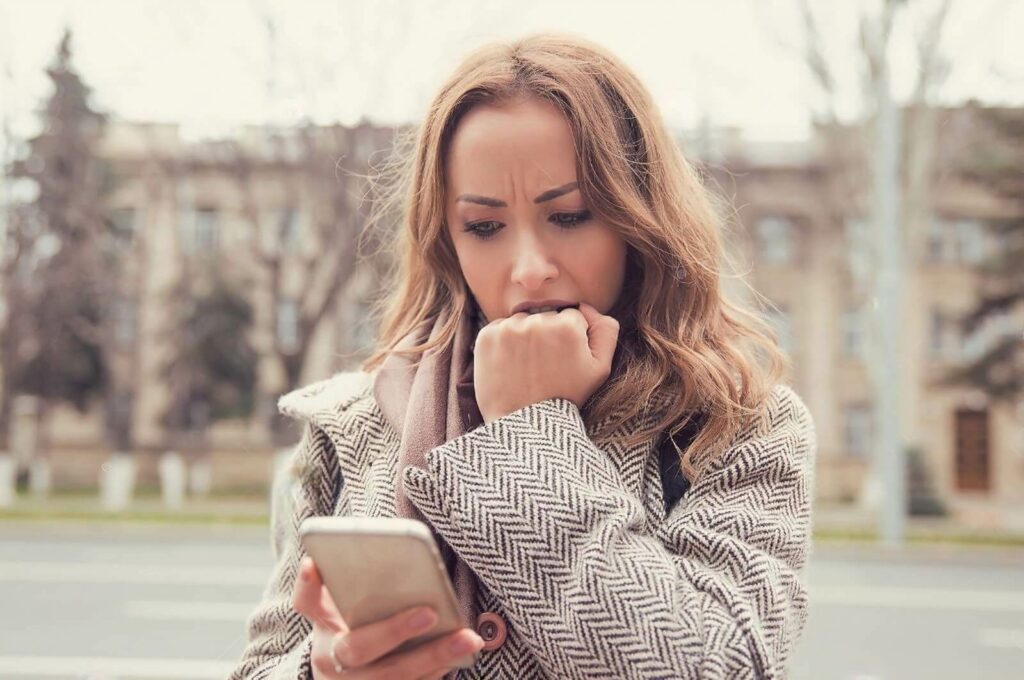 How-To-Ask-a-Girl-Out-Over-Text-Woman-Looking-Nervous-At-Phone